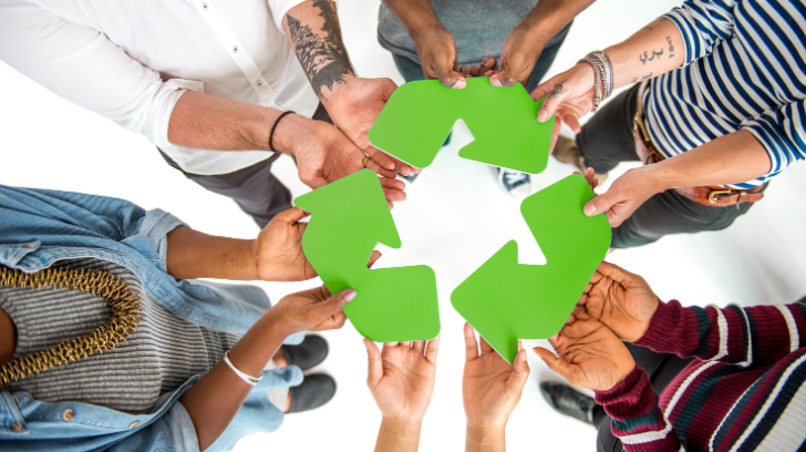 on voit un groupe de personne en rond tenant le tous le logo du recyclage